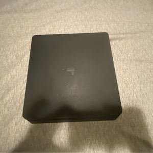 Ps4 slim with a red controller and cables